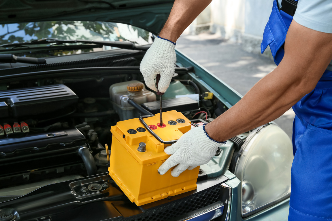 Male Mechanic Fixing Car Battery